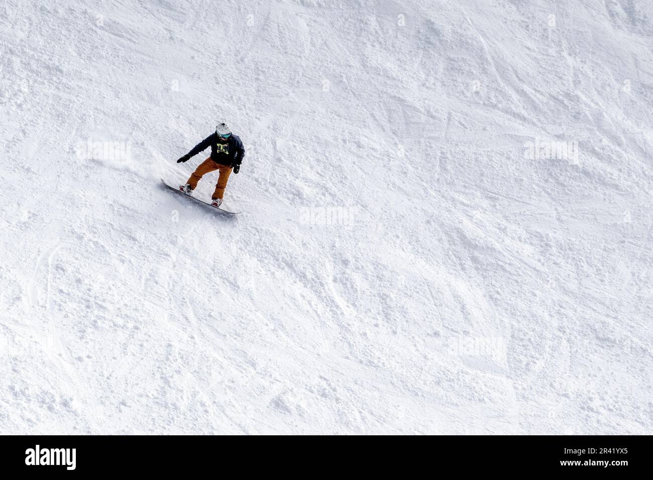 Snowboarder descendant une pente raide Banque D'Images