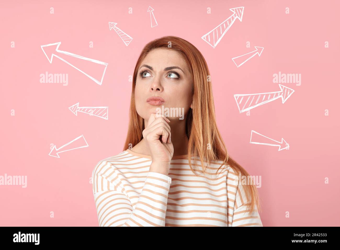 Choix dans la profession ou dans d'autres domaines de la vie, concept. Prise de décision, femme réfléchie entourée de flèches dessinées sur fond rose Banque D'Images