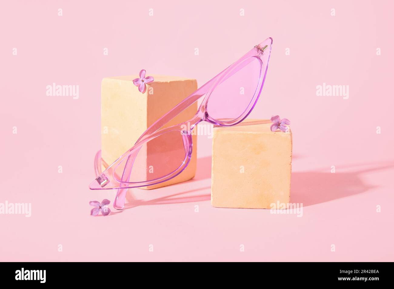 Podiums avec lunettes de soleil élégantes sur fond rose Banque D'Images