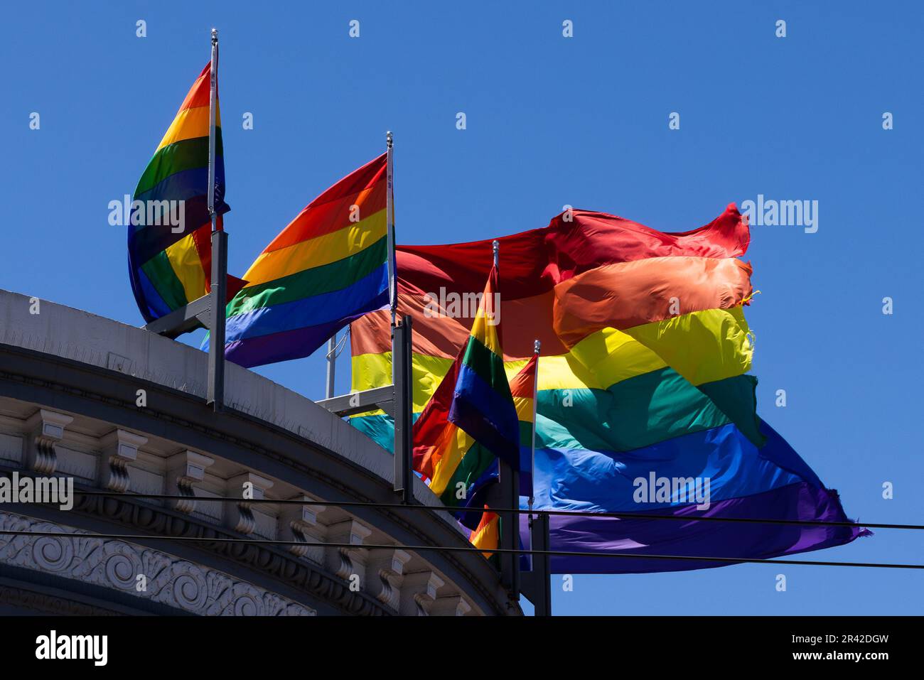 Des drapeaux arc-en-ciel éclatants dans un ciel bleu. Le quartier de Castro, San Francisco. Des drapeaux multicolores flottent dans le vent par temps ensoleillé. Banque D'Images