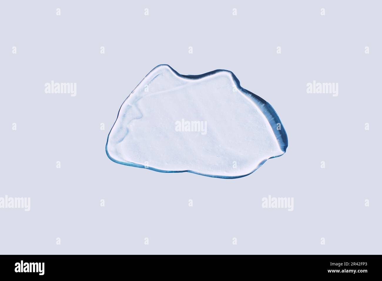 Gel liquide abstrait taches cosmétiques sur un fond bleu avec des ombres dures Banque D'Images