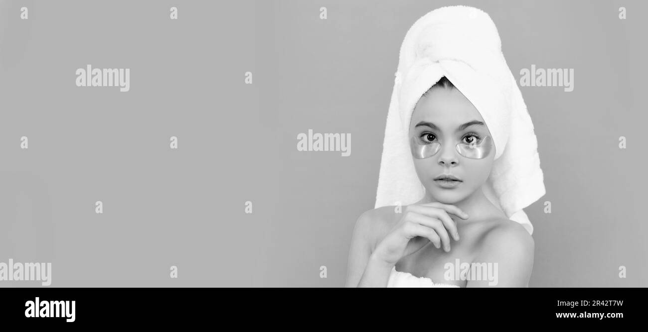 une jeune fille dans une serviette de douche avec un patch de beauté. Cosmétiques et soins de la peau pour enfant adolescent, design poster. Bannière enfant fille beauté avec espace de copie. Banque D'Images