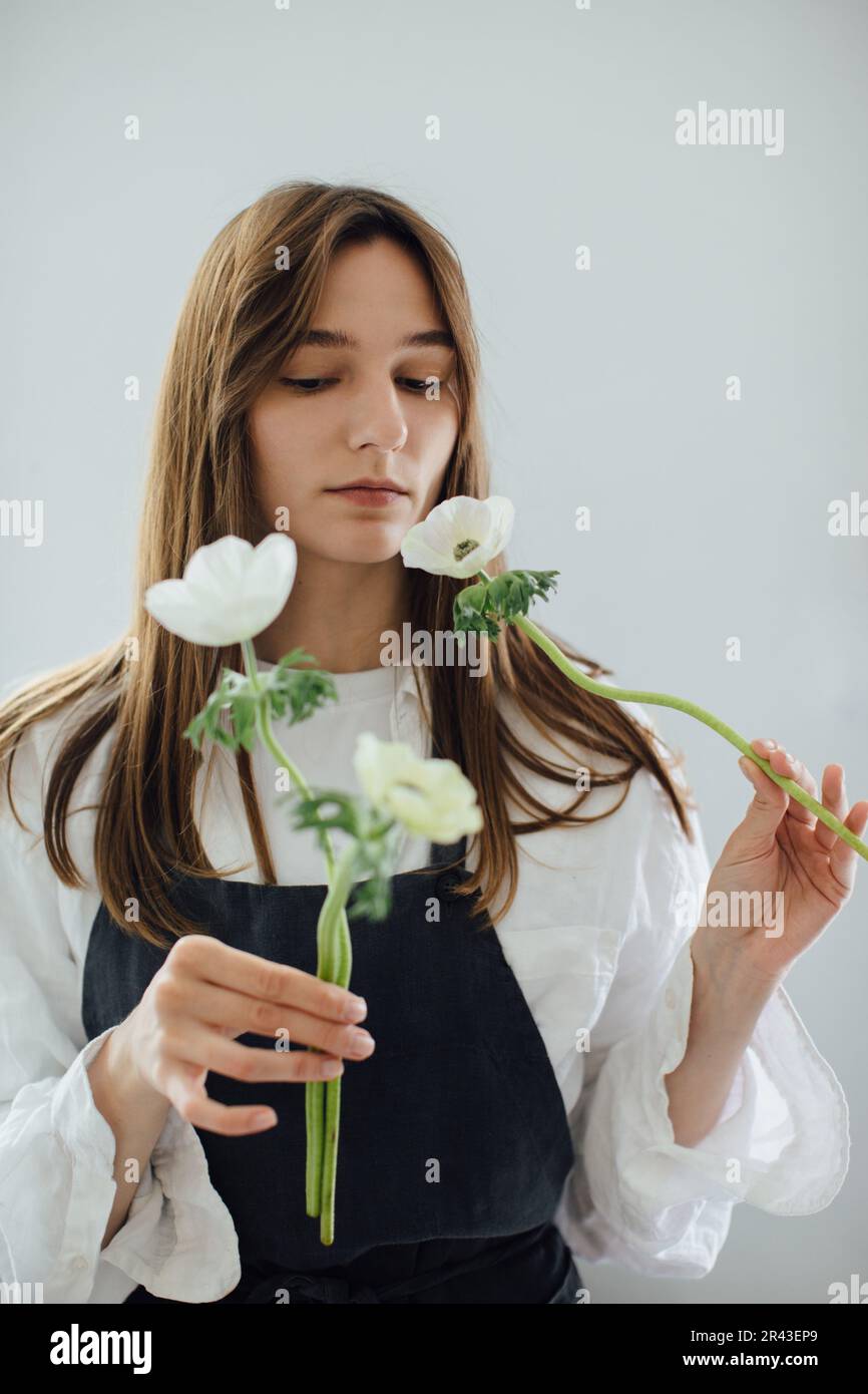 Une jeune fille fleuriste fait un arrangement de fleur. Banque D'Images