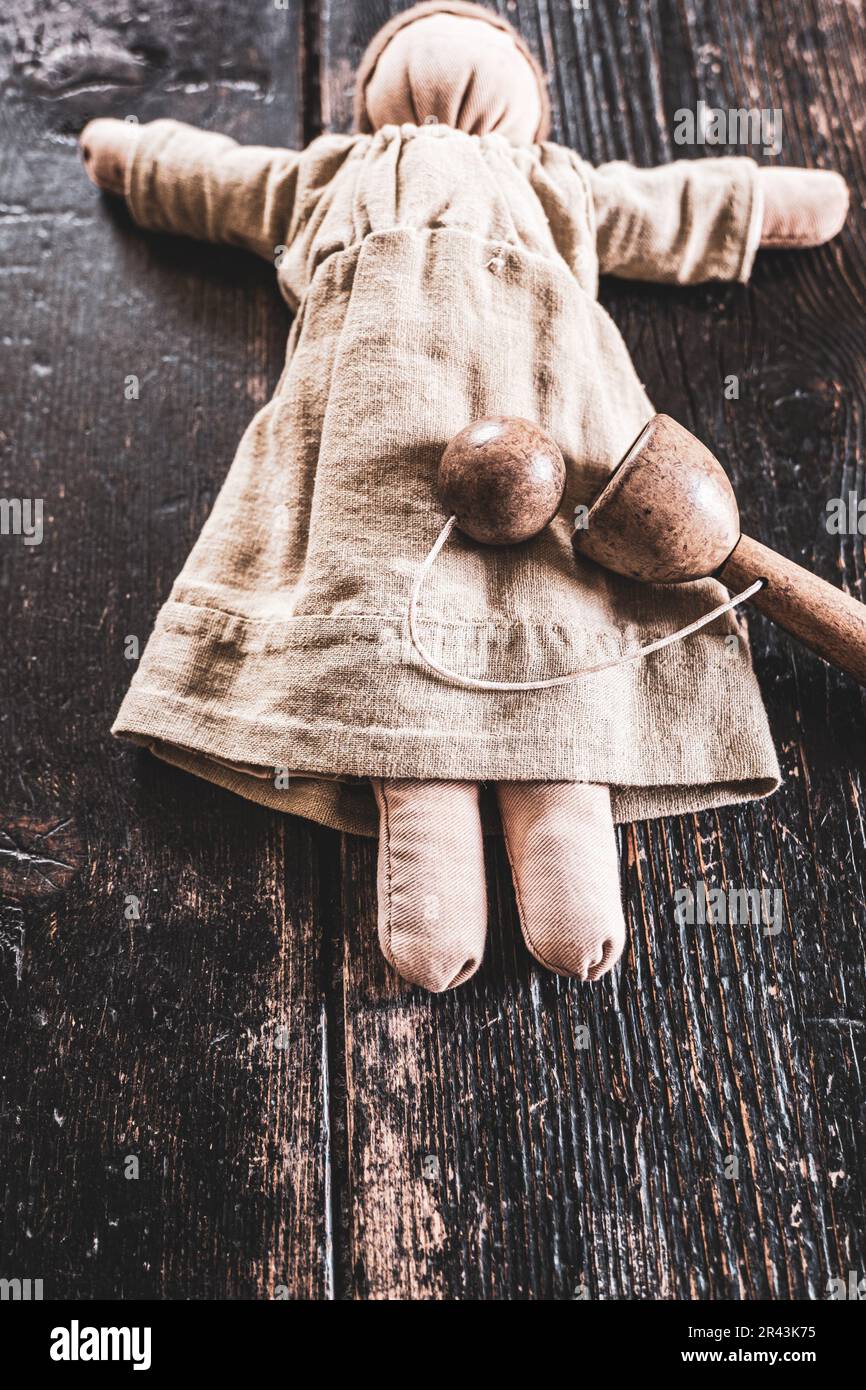 Jouet de poupée de chiffon pour enfants et jeu de tasse et de balle sur des planches de bois. Banque D'Images