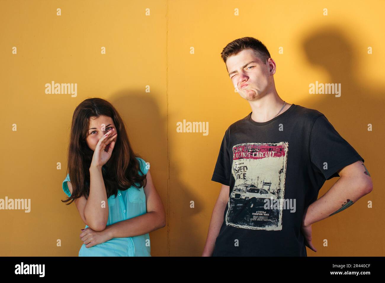 garçon et fille près du mur orange Banque D'Images