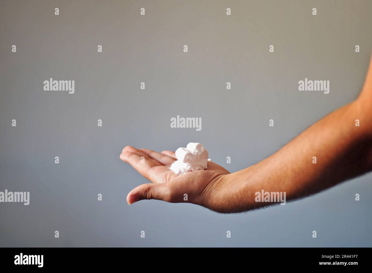 Homme avec de la mousse à raser dans sa main. Banque D'Images