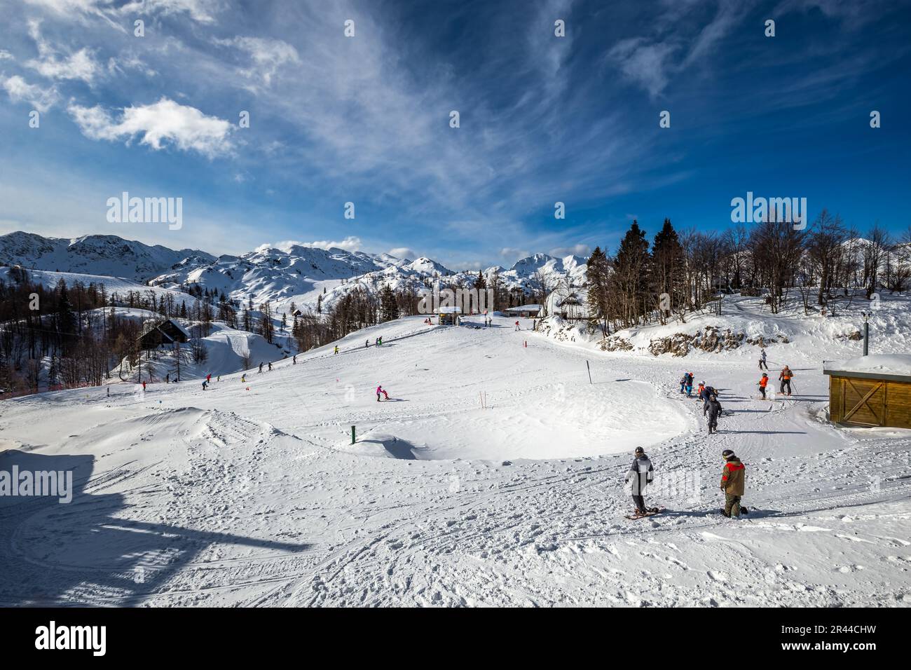 Bohinj, Slovénie - Station de ski de Vogel à Bohinj, dans les Alpes Juliennes, par une belle journée d'hiver avec pistes de ski, skieurs, snowboarders et ciel bleu et nuages Banque D'Images