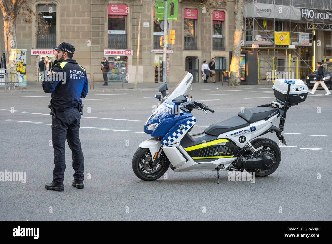 Un agent de la police urbaine avec son scooter BMW C Evoluiton régulant la circulation à un carrefour Banque D'Images