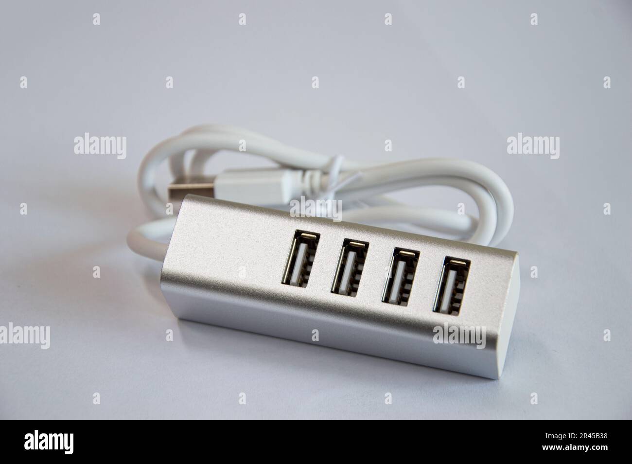 Concentrateur USB à 4 ports, argenté, placé sur un fond blanc Banque D'Images