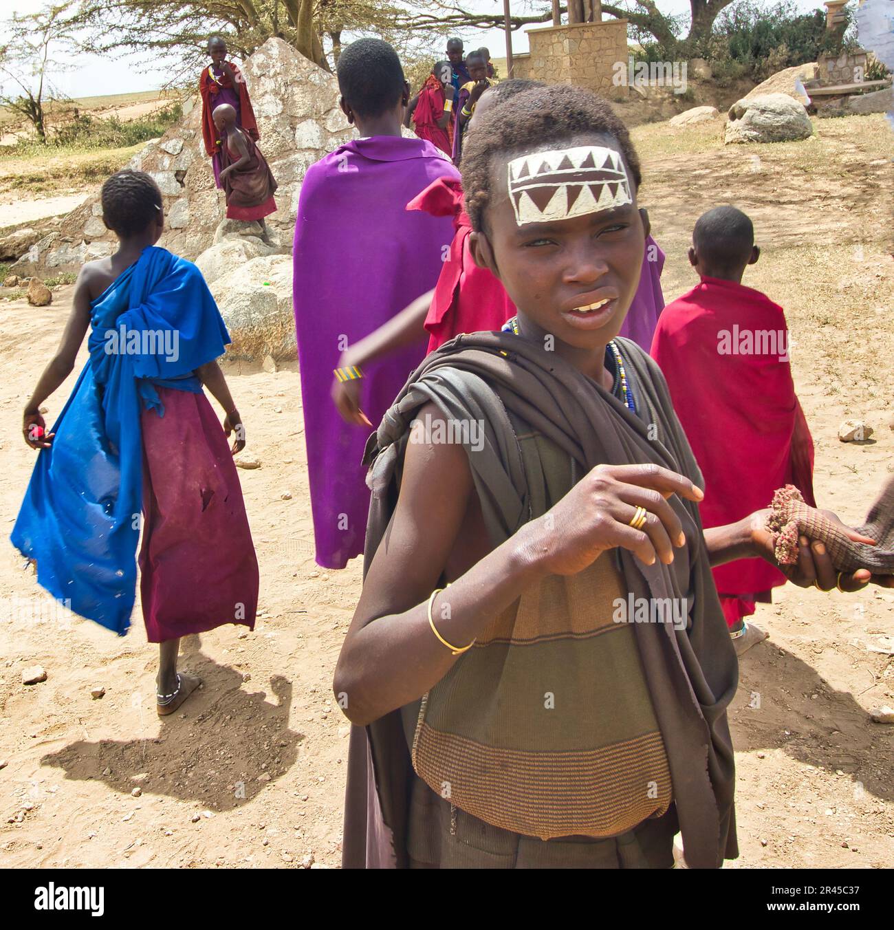 30 décembre 2017, parc national du Serengeti, Tanzanie - Un jeune maasai moran appelle pour plus d'eau lors d'une journée sèche et chaude à l'entrée du parc national du Serengeti Banque D'Images