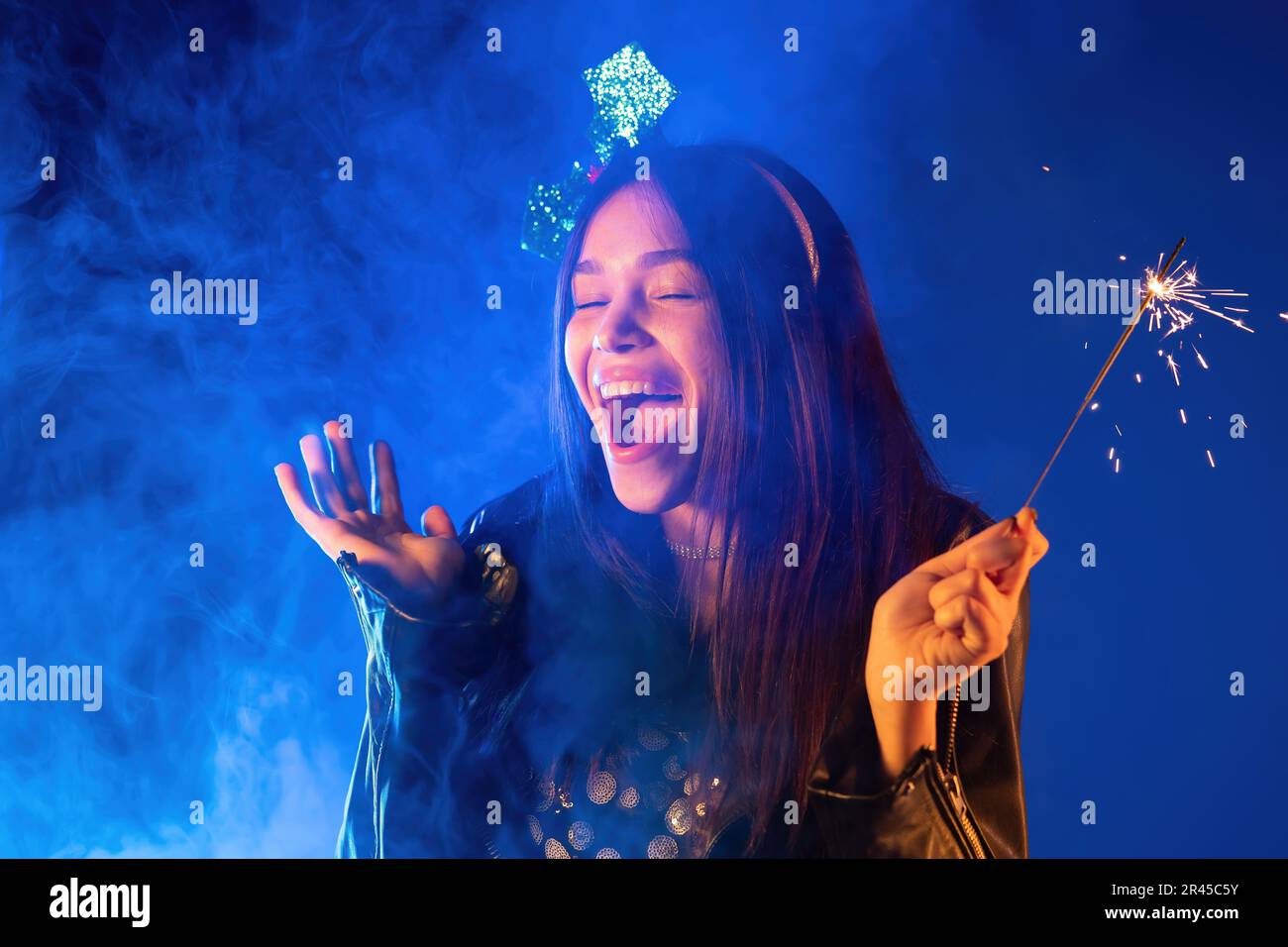 Jeune fille asiatique adolescente dansant avec le feu de sparkle bengale sous lumière de néon. Fête du nouvel an ou de Noël. Images animées de la femme heureuse. Banque D'Images