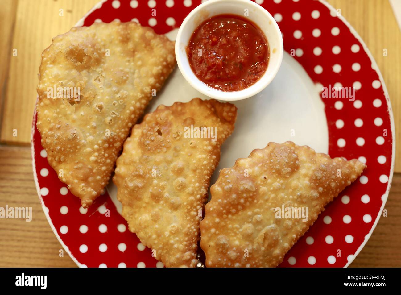 Trois chebureki avec sauce tomate sur l'assiette du restaurant Banque D'Images