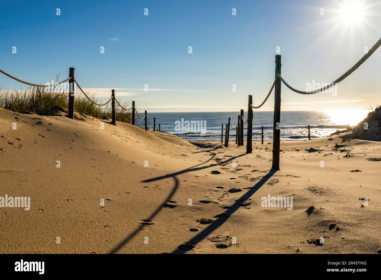 Une belle scène de plage du Delaware au coucher du soleil, avec une clôture en bois le long du rivage Banque D'Images