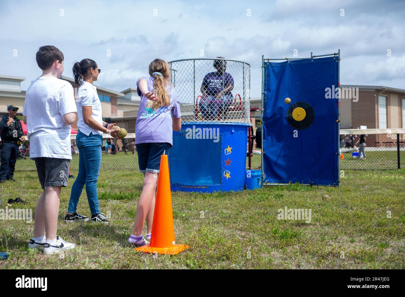 Un enfant jette un ballon tout en jouant à un dunk tank lors d