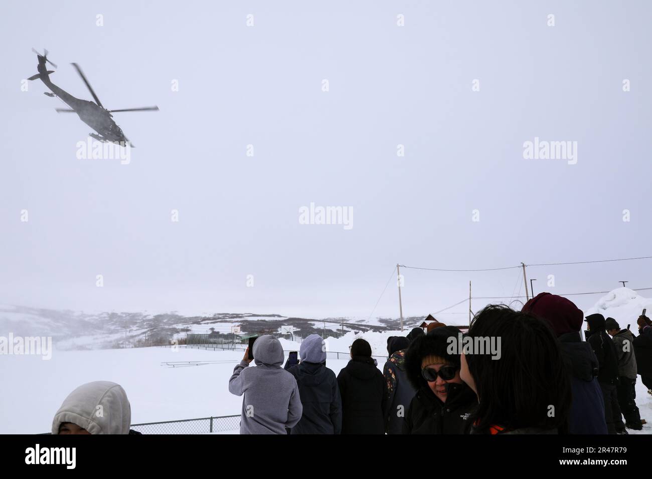 Les membres de la communauté regardent un hélicoptère UH-60 Black Hawk de la Garde nationale de l'Armée de l'Alaska au départ de St. Mary’s 31 mars 2023. L'Association des présidents de conseil de village s'est récemment associée à la Garde nationale de l'Alaska pour fournir des renseignements et des ressources sur le recrutement par l'intermédiaire de leurs centres d'emploi tribaux. L'initiative a débuté à St. Mary’s avec des présentations de l’AVCP et de l’AKNG à l’école secondaire Andreafski où des représentants ont interagi avec des étudiants, des parents, des enseignants et des membres de la communauté. AVCP offre des services de développement communautaire, d'éducation, de services sociaux, de programmes culturellement pertinents et d'advoc Banque D'Images