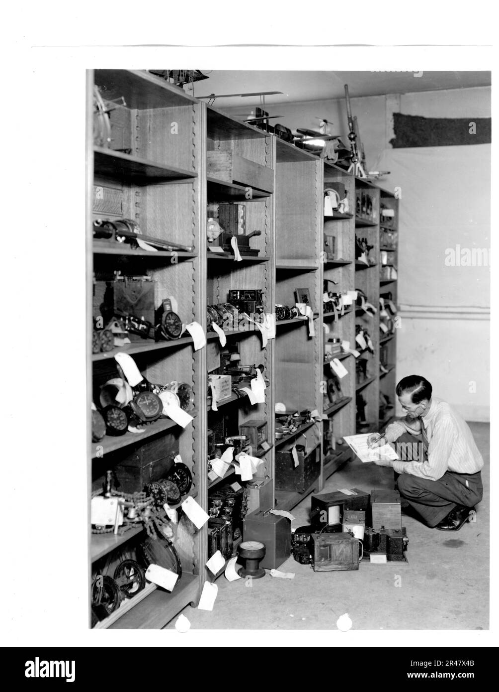 Le chercheur Dale L. Poorman indexe et classe les instruments aéronautiques entreposés au musée du bâtiment 12 en 1940. Les instruments ont ensuite été utilisés pour des expositions classées par valeur technique et historique. Banque D'Images
