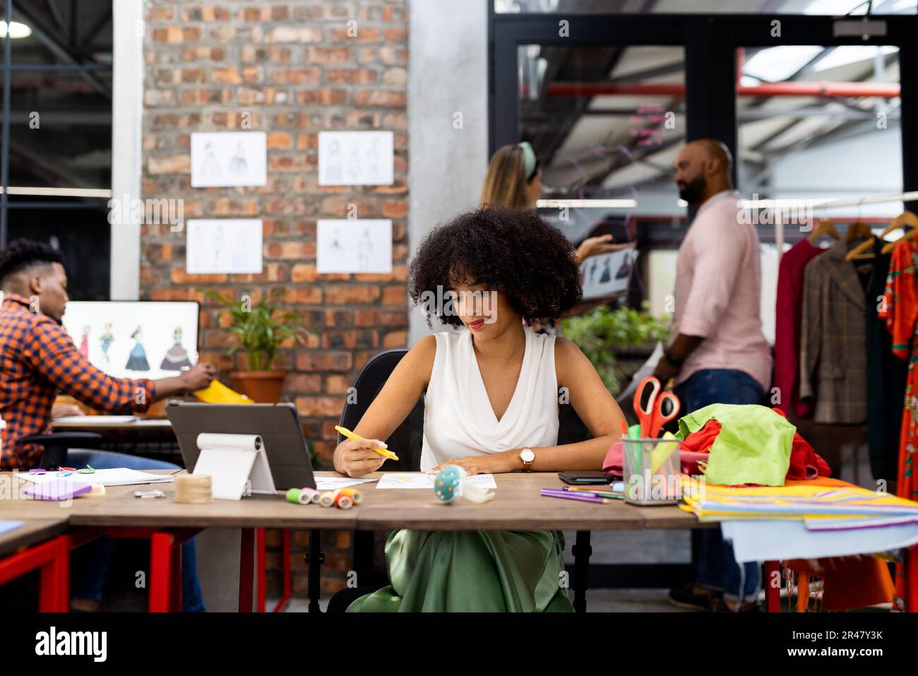 Nombreux créateurs de mode divers faisant des projets de mode dans le bureau créatif, sans modification Banque D'Images