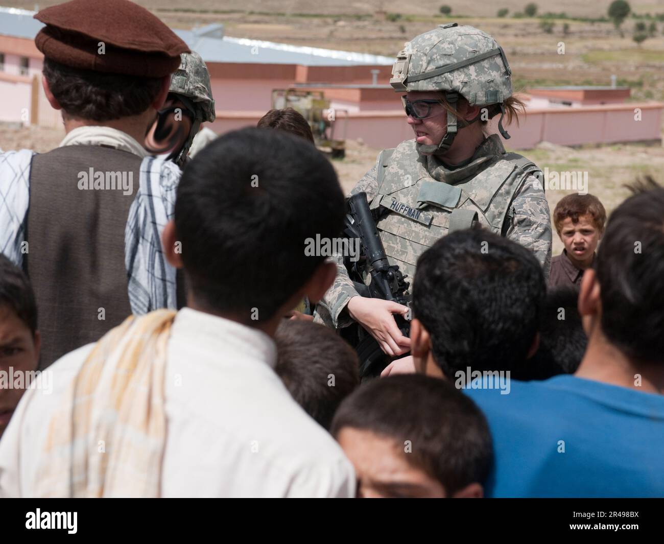 (Province de Kapisa, Afghanistan) États-Unis Force aérienne 1st le lieutenant Amanda Huffman parle avec les Afghans locaux à l'extérieur de la nouvelle école Malakar dans le village de Durnama. Le lieutenant Huffman est membre de l'équipe de reconstruction provinciale de Kapisa et effectue régulièrement des missions dans tout Kapisa pour interagir et interagir avec les dirigeants locaux. La mission de l'EPR est de stabiliser la région en permettant aux gouvernements locaux de s'occuper, d'éduquer, d'employer et de protéger leur population grâce à la construction d'infrastructures de base et au mentorat. Banque D'Images