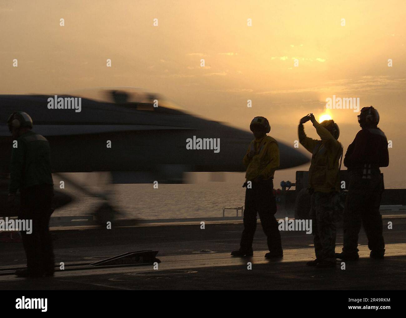 LES directeurs du pont DE L'US Navy Flight positionnent un avion sur l'un des quatre catapultes à vapeur à bord de l'USS George Washington (CVN 73) tandis qu'un F-A-18C Hornet se lance derrière eux Banque D'Images