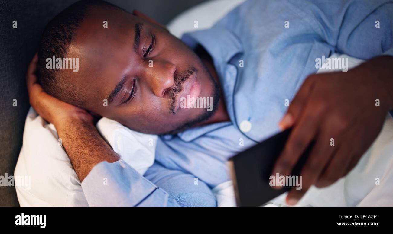 Regarder un téléphone portable avant de dormir la nuit dans la chambre Banque D'Images