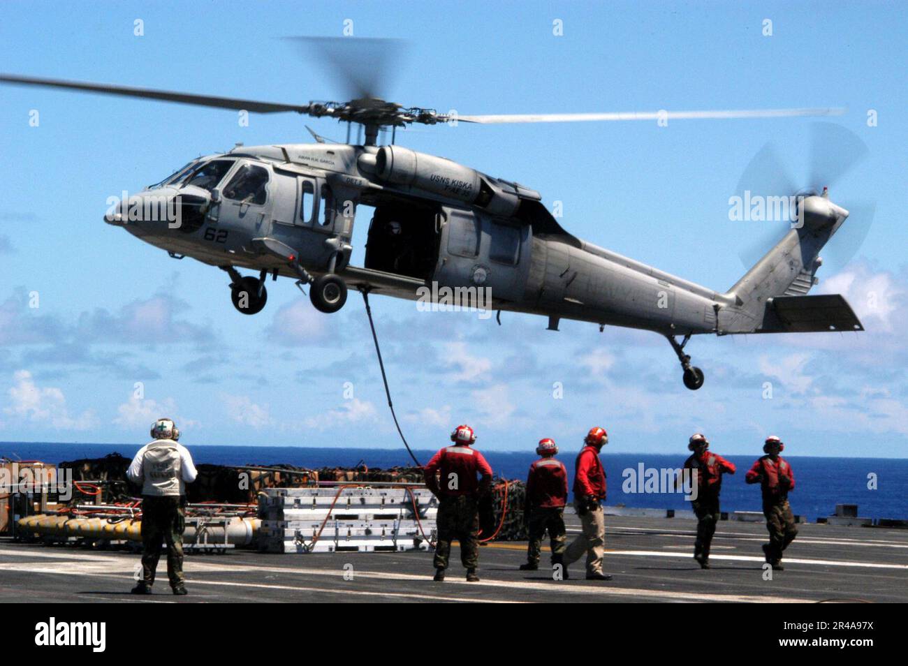 LES soldats DE l'aviation DE LA Marine AMÉRICAINE se tiennent à l'écart lorsqu'un hélicoptère MH-60s Knight Hawk transfère des munitions entre l'USS Kitty Hawk (CV 63) et le navire de munitions USNS Shasta (T-AE 33) Banque D'Images