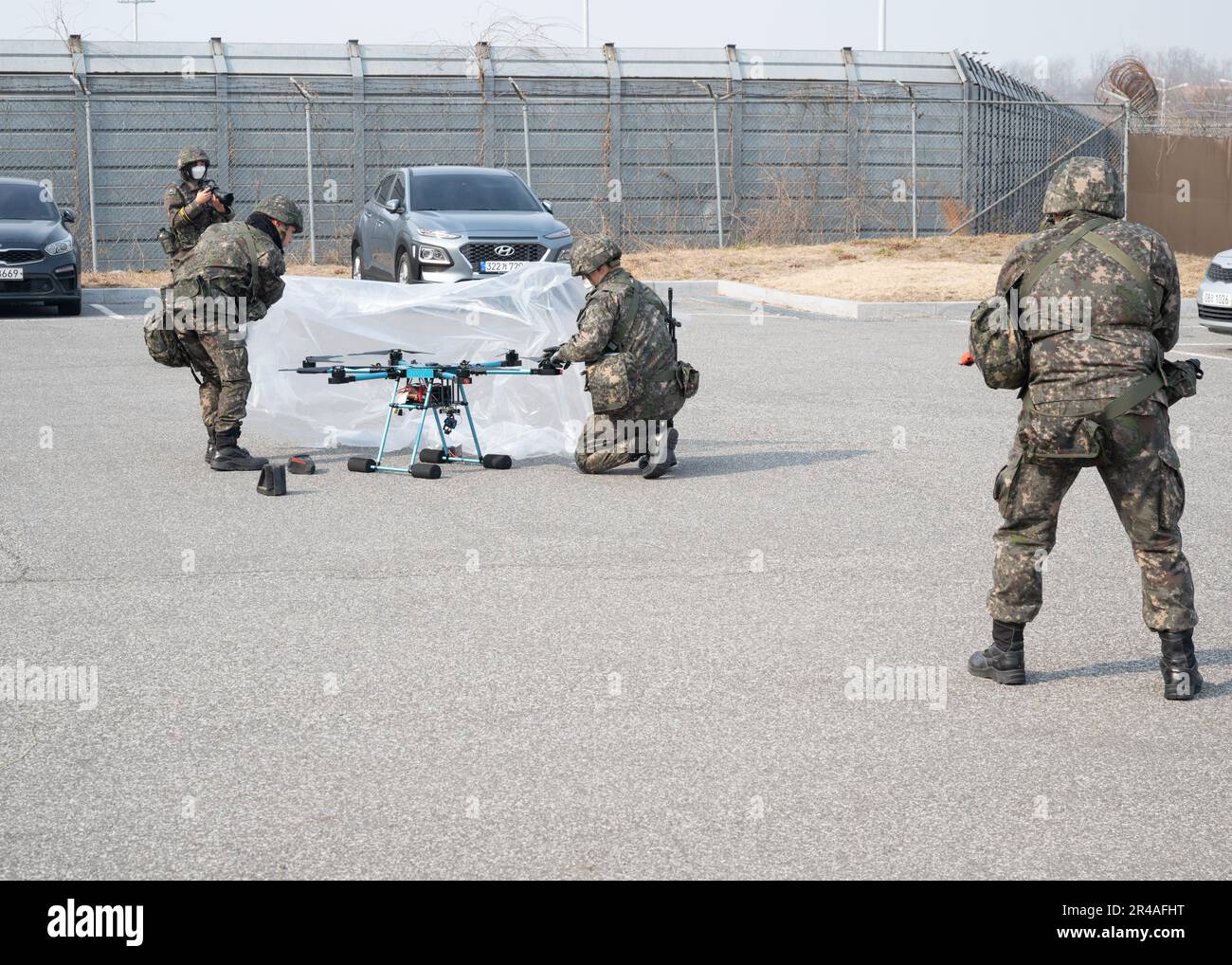 République de Corée (ROK) les policiers militaires du groupe de chasseurs 38th enveloppent un drone ennemi simulé d'une feuille de plastique à la base aérienne de Kunsan, ROK, le 7 février 2023. La feuille en plastique empêche le drone de voler. Banque D'Images