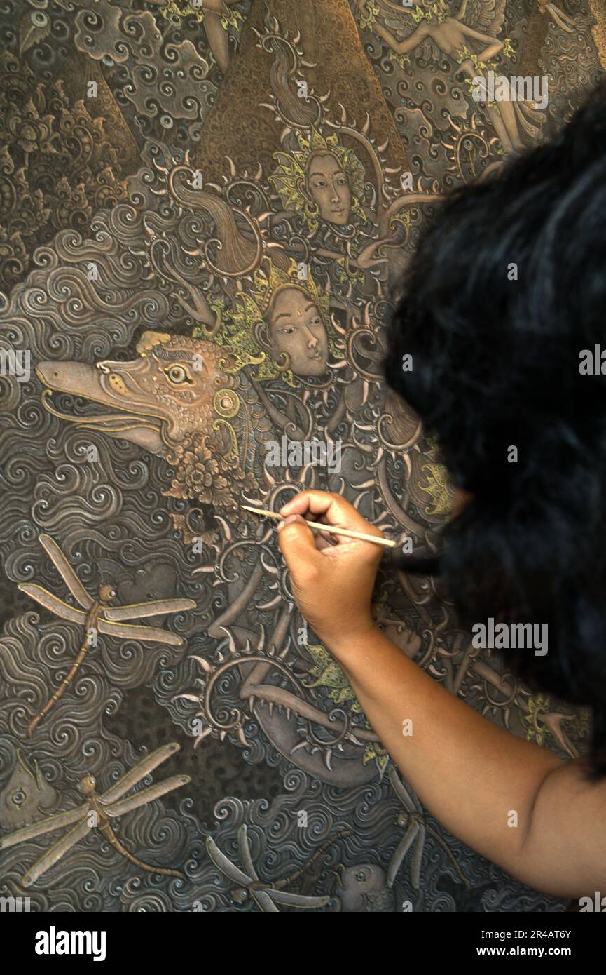 Un peintre travaille sur une peinture à Tebesaya (Tebasaya), une région connue dans le monde des arts balinais pour son rôle et sa contribution dans 'Tebesaya style de peinture' et 'Ubud école de peinture' située à Ubud, Gianyar, Bali, Indonésie. Banque D'Images