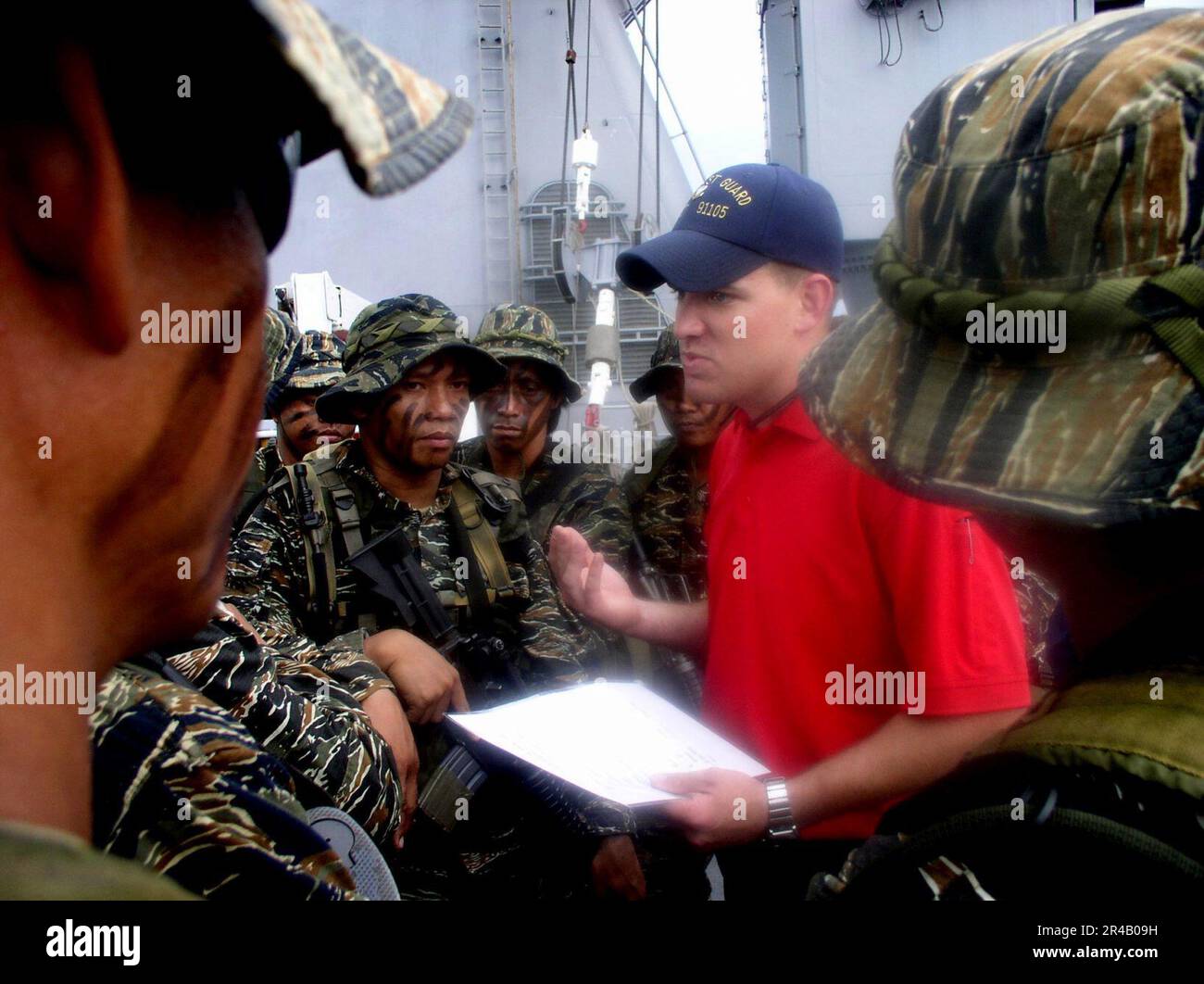 US NAVY A U.S. Un spécialiste de l'application de la loi de la Garde côtière fait le bilan des membres d'une équipe DE PHOQUES de la Marine philippine à la suite d'un exercice de visite, d'embarquement, de perquisition et de saisie (VBSS) à bord du navire d'atterrissage à quai USS fort McHenry. Banque D'Images US NAVY A U.S. Un spécialiste de l'application de la loi de la Garde côtière fait le bilan des membres d'une équipe DE PHOQUES de la Marine philippine à la suite d'un exercice de visite, d'embarquement, de perquisition et de saisie (VBSS) à bord du navire d'atterrissage à quai USS fort McHenry. Banque D'Images