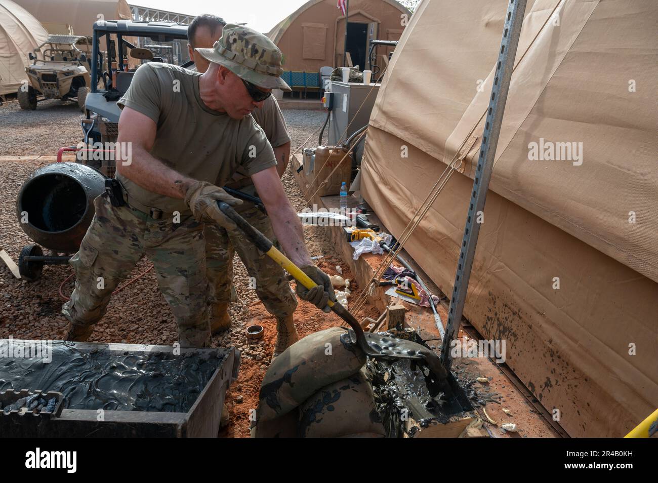 ÉTATS-UNIS Le Sgt. Kevin Lake, commandant principal de la Force aérienne, 768th escadron de la base aérienne expéditionnaire, vol du Génie civil, décolle le ciment dans un trou pour soutenir un poste de lumière à l'AB 101, Niger, 4 avril 2023. L'éclairage nouvellement installé assurera la sécurité autour des zones de travail dans des heures d'obscurité. Banque D'Images