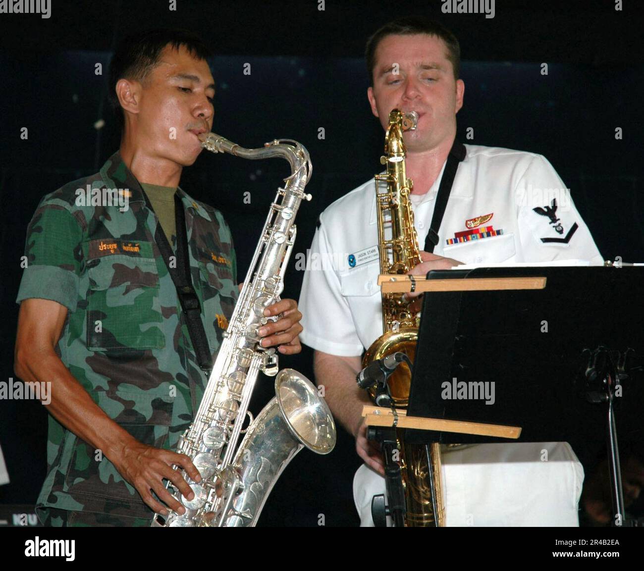 MUSICIEN DE la Marine AMÉRICAINE 3rd classe du groupe de la flotte 7th, ''Orient Express'' joue aux côtés d'un homologue du Royal Thai Marine Band lors d'une représentation à l'école élémentaire Singsamut de Satt. Banque D'Images