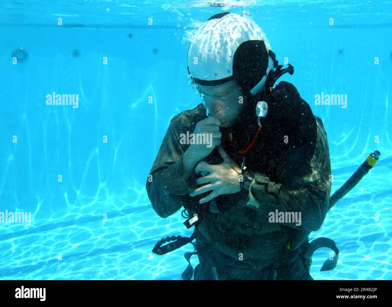 US Navy Un étudiant qui participe au cours de recyclage sur la survie de l'eau au centre d'entraînement de survie de l'aviation, Marine corps Air Station Miramar, gonfle oralement son gilet de survie. Banque D'Images