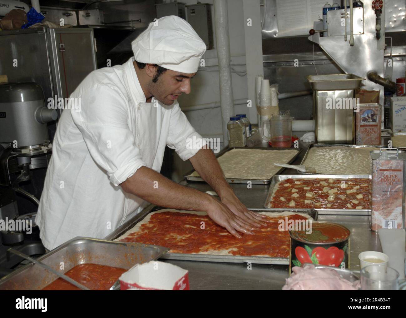 US Navy un cuisinier italien affecté au navire italien ITS Granatière (F585), fait de la pizza à bord du navire de transport amphibie USS Nashville (LPD 13). Banque D'Images