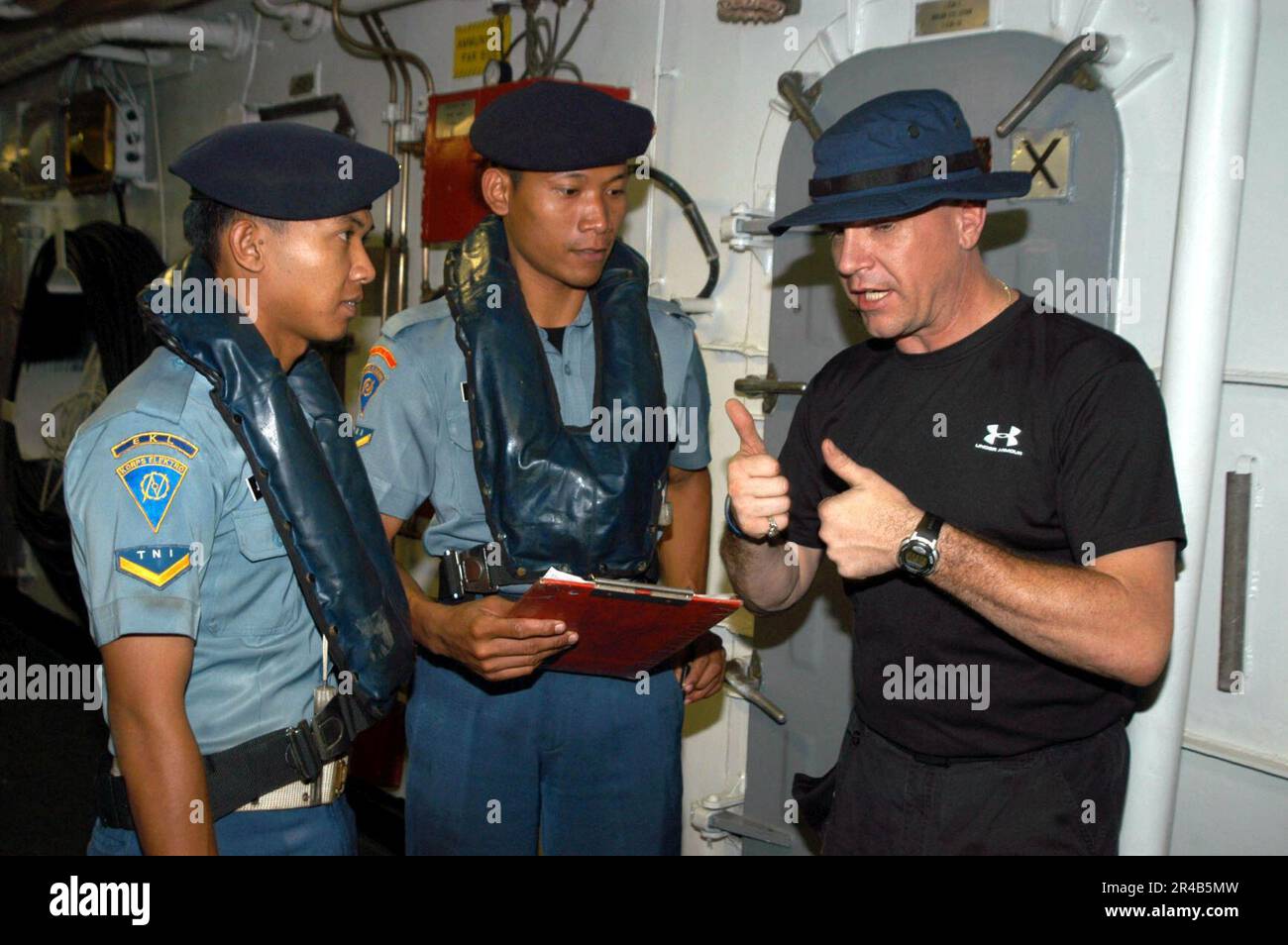 TECHNICIEN DE la Marine AMÉRICAINE Hull 1st membre de l'équipe de classe a visite, conseil, perquisition et saisie (VBSS) à bord de la frégate de missile guidée USS Rodney M. Davis (FFG 60) parle des procédures de son équipe avec an Banque D'Images