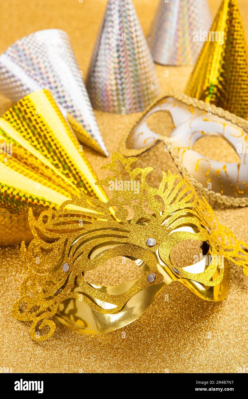 Motif de fête avec masque de carnaval et chapeau de fête en ton d'or Banque D'Images