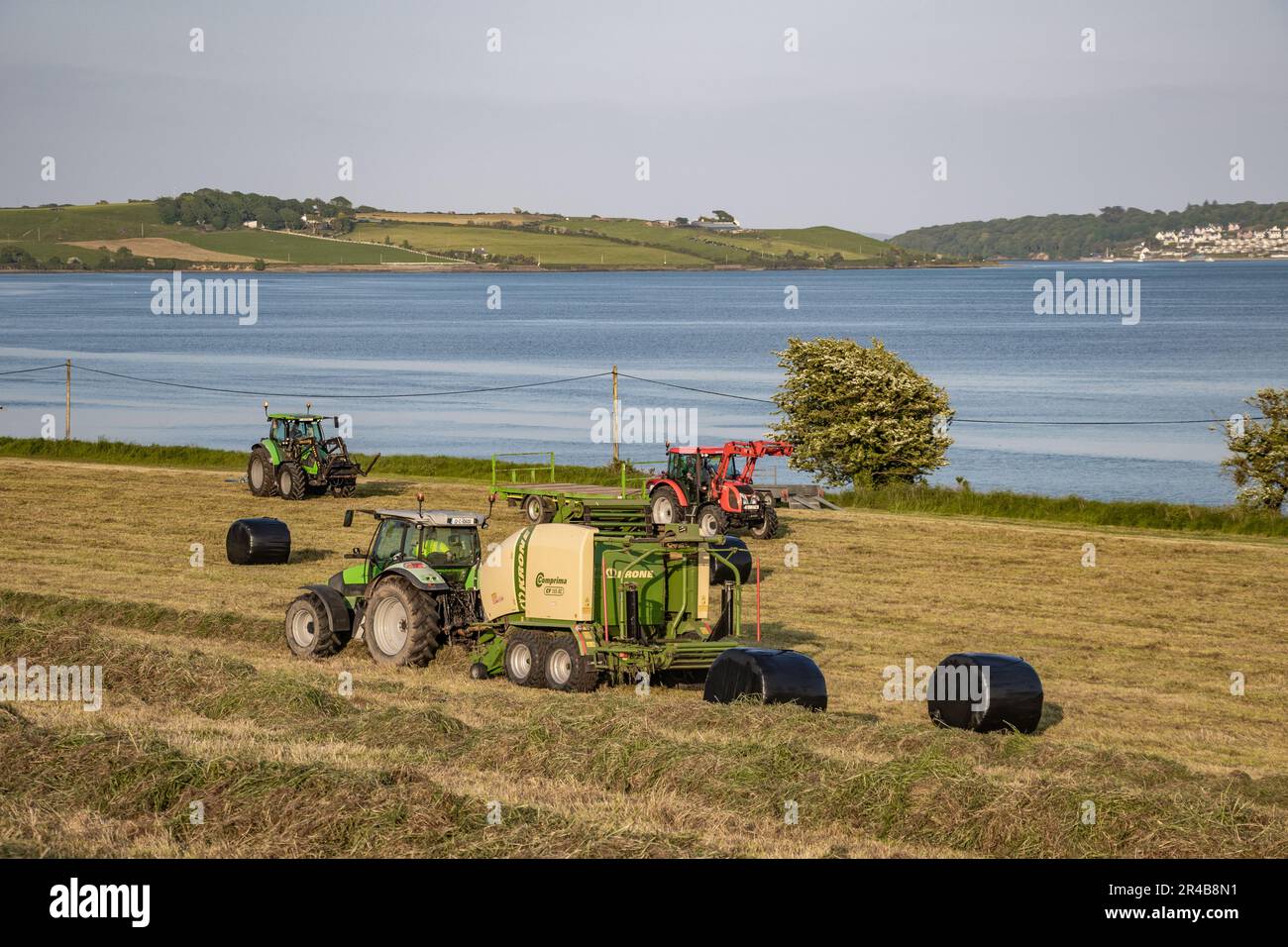 L'agriculteur de Timoleague balle de l'ensilage surplombant la baie de Coutmacsherry. Banque D'Images