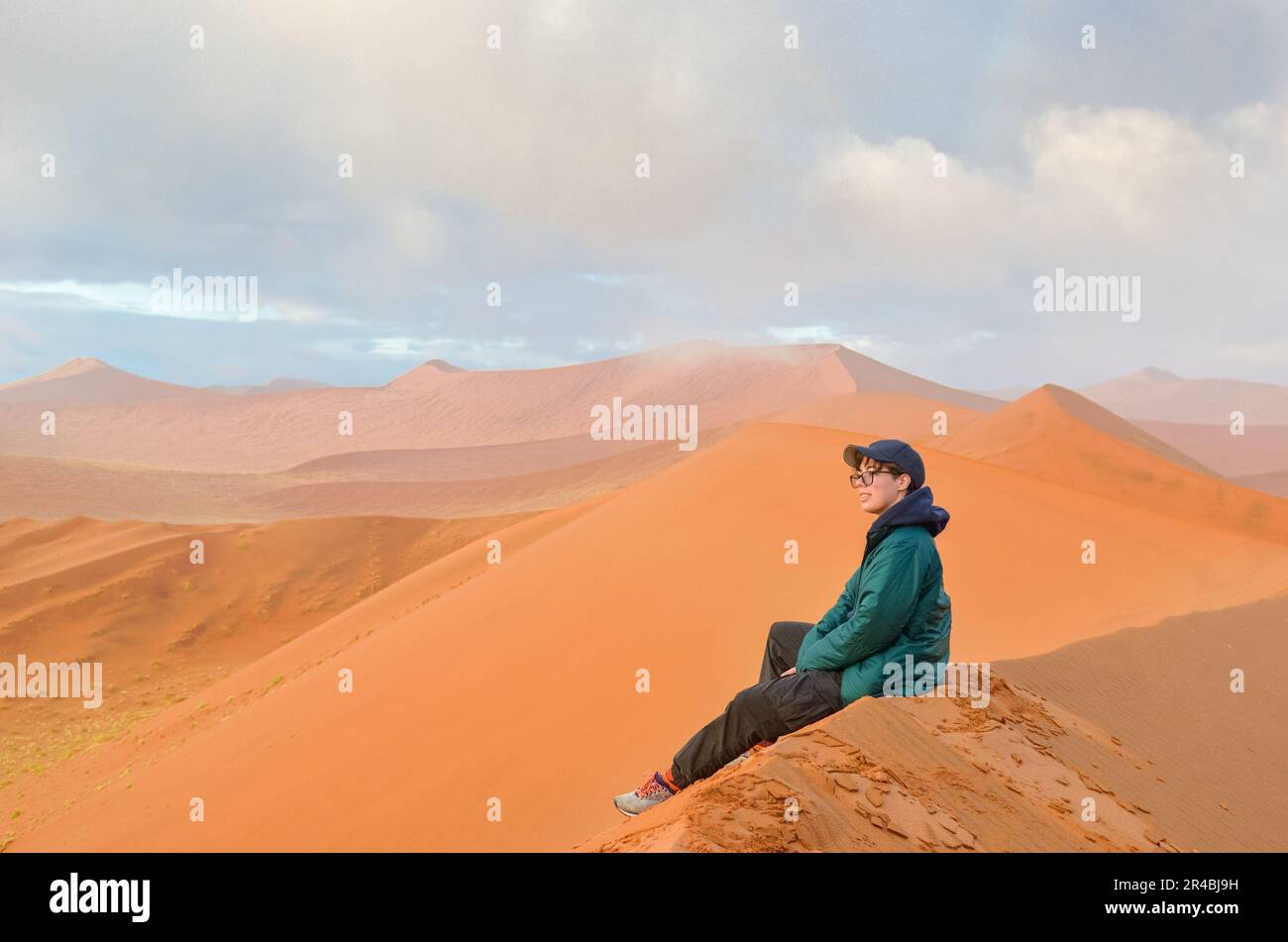 Femme touriste assise sur une dune de sable du désert du Namib, Sossusvlei, Namibie, Afrique du Sud Banque D'Images