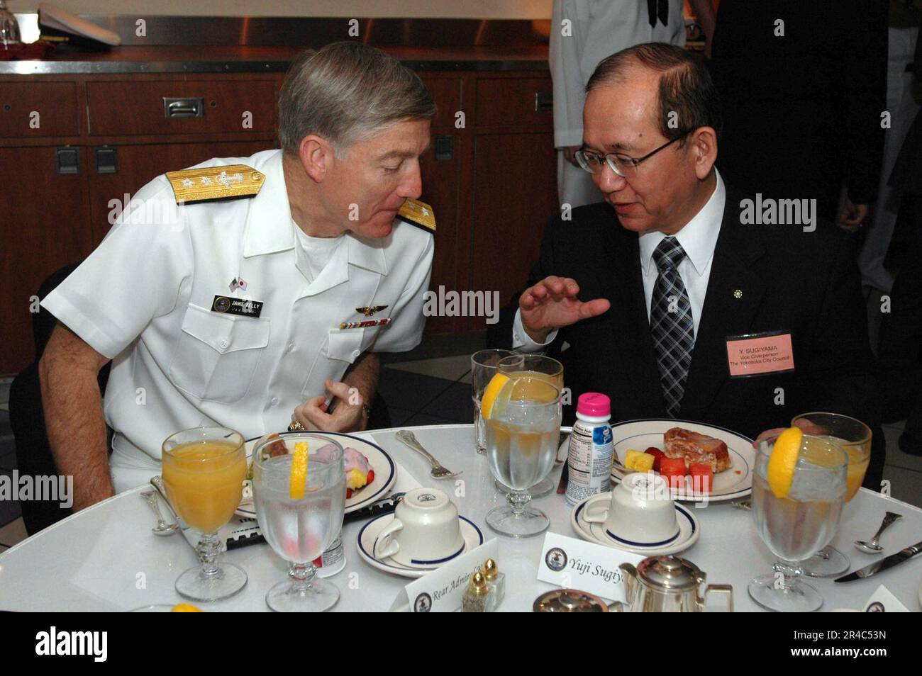 JAMIE Kelly, SMA de la Marine AMÉRICAINE, à gauche, et Yuji Sugiyama, délégué japonais, discutent avant de prendre le petit-déjeuner à bord du porte-avions de classe Nimitz USS John C. Stennis (CVN 74). Banque D'Images