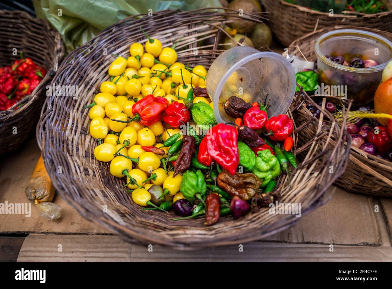 Un assortiment de fruits et légumes frais et vivants présentés dans des paniers en osier avec couvercles en plastique Banque D'Images