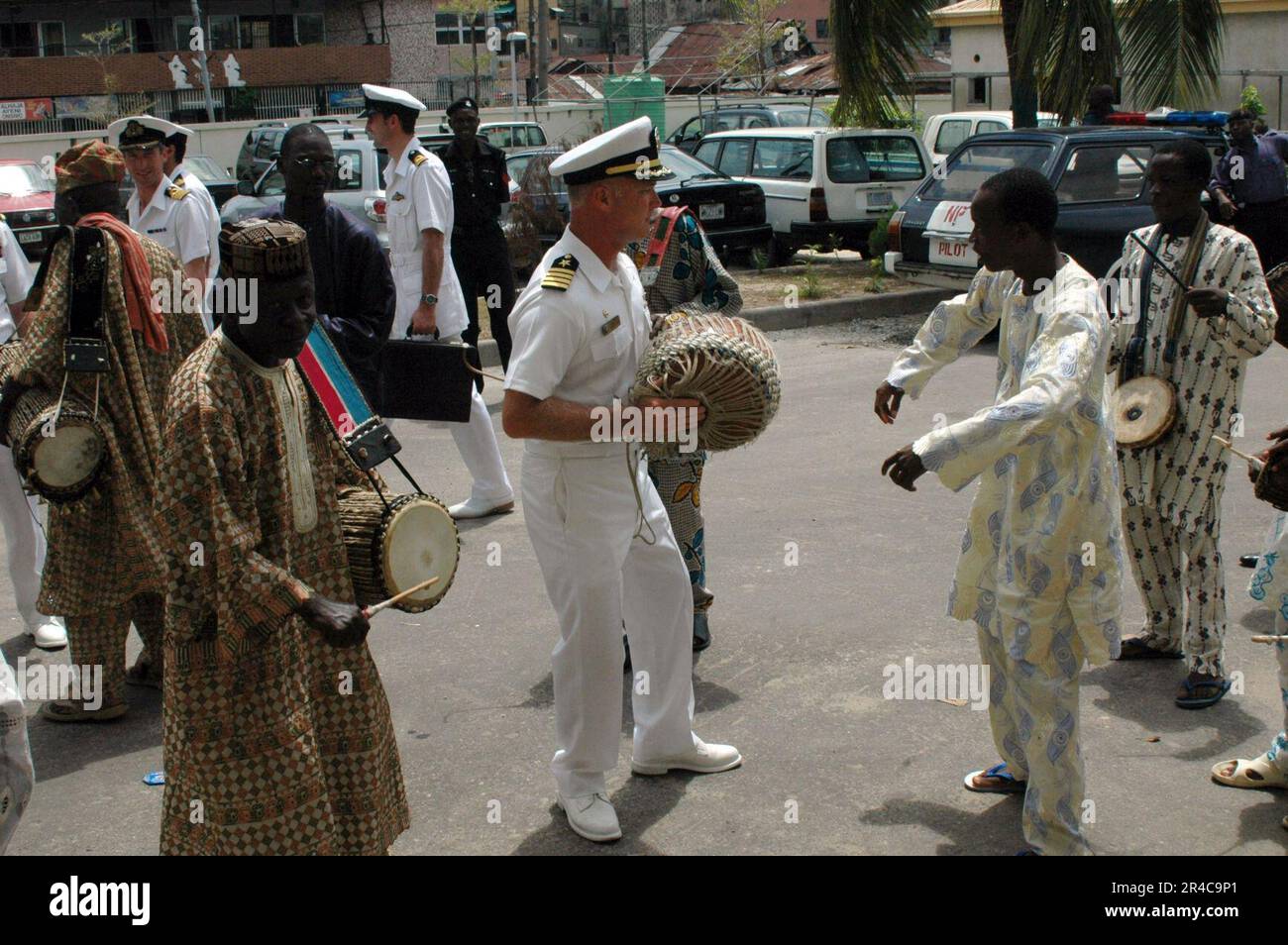 Commandant DE la Marine AMÉRICAINE, Dentroyer Squadron six Zero (COMDESRON-60), Commodore danse avec un batteur avec l'Oba de Lagos, au Nigeria. Banque D'Images