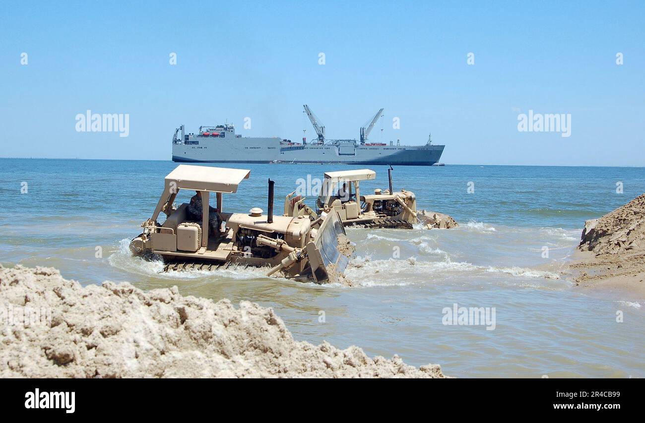 Les marins DE la Marine AMÉRICAINE affectés au Bataillon de construction amphibie deux (ACB-2) débarrasse un étang de canard dans le surf à marée haute afin de se balader sur la jetée de Triton (portable) de l'Armée. Banque D'Images