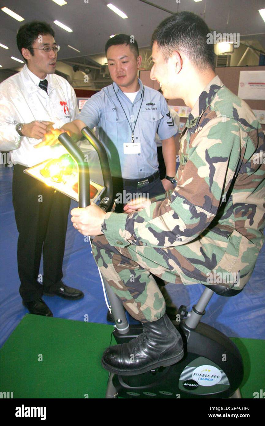 LA classe 2nd DU PETTY Officer DE LA marine AMÉRICAINE génère de l'électricité sur un vélo tandis que la compagnie d'énergie électrique de Tokyo explique le processus lors de la quatrième foire annuelle de l'énergie d'Atsugi. Banque D'Images