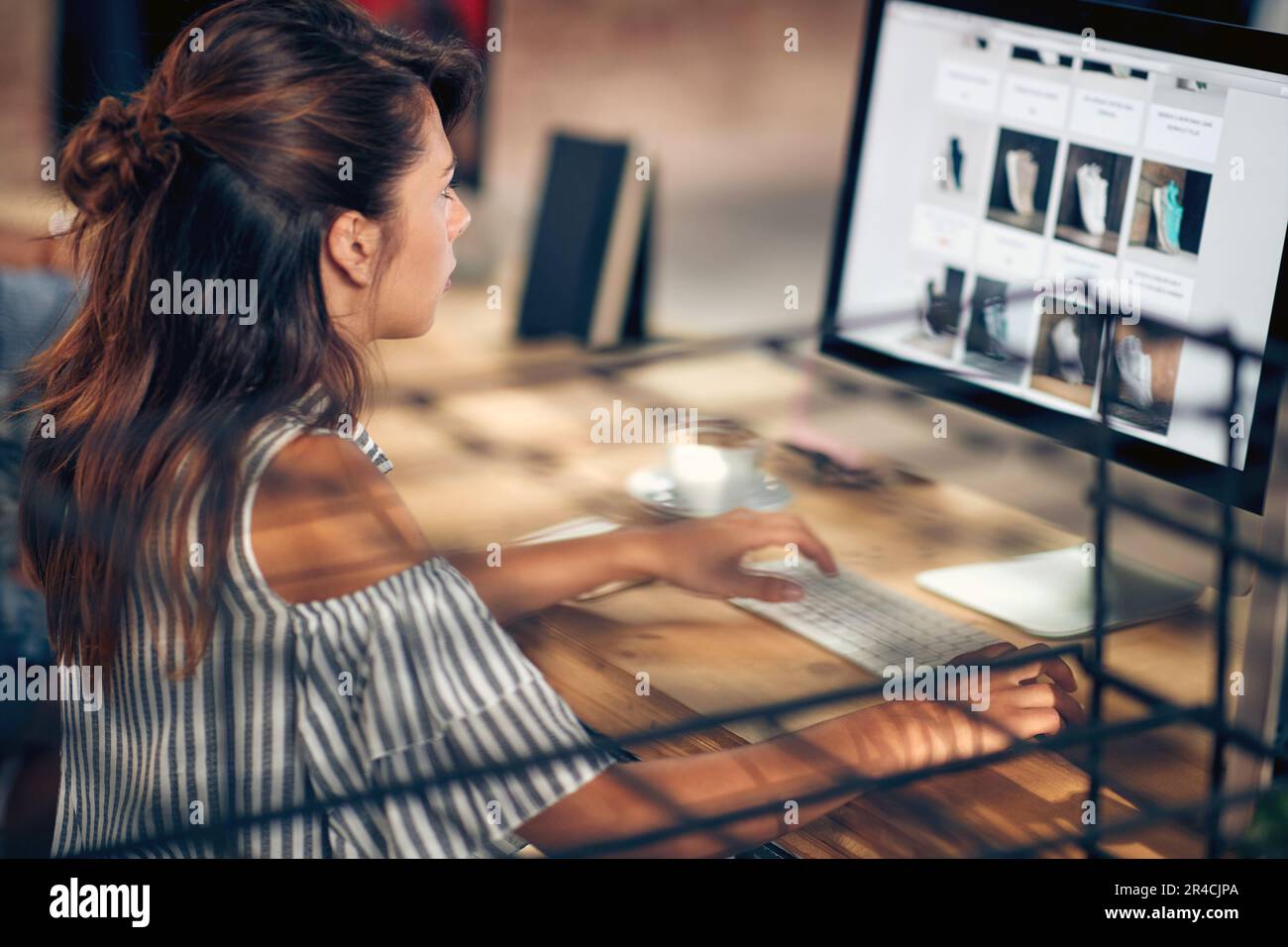 Jeune femme avec un café regardant l'ordinateur, la navigation sur Internet. Achats sur Internet. Banque D'Images
