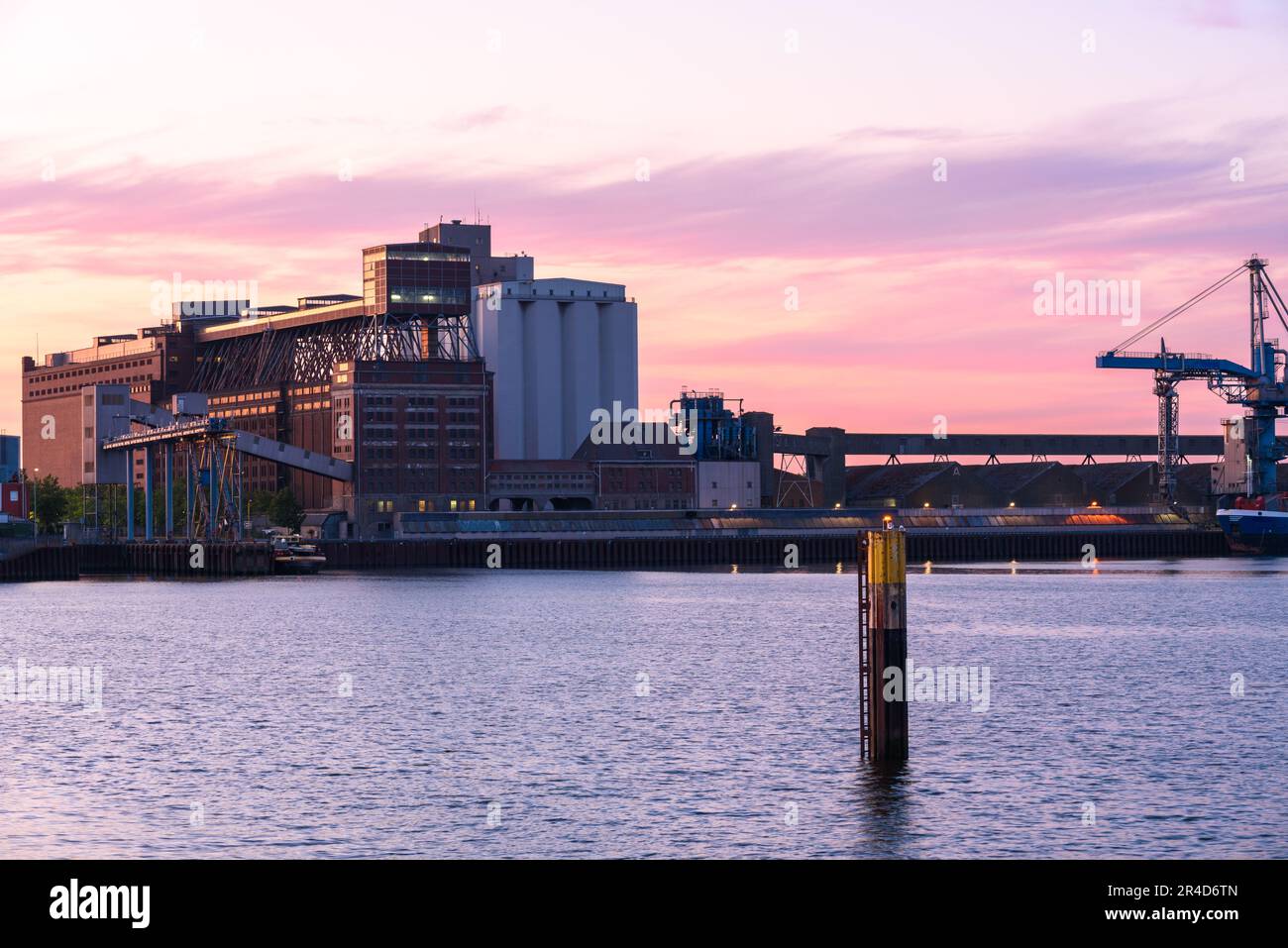 Maisons de guerre et silos sur un quai commercial sur un port fluvial au crépuscule en été Banque D'Images