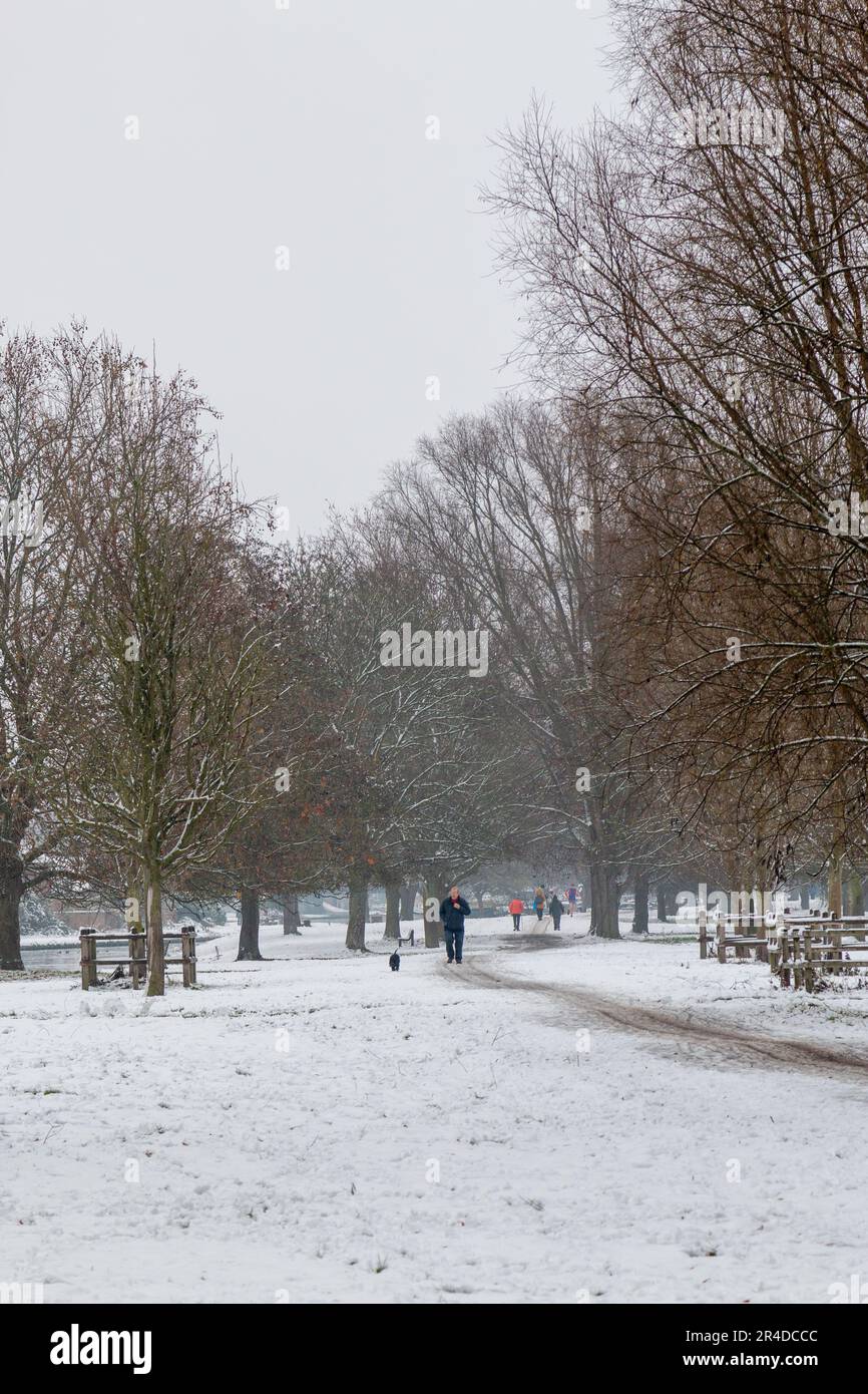 Des gens qui marchent dans la neige sur Stourbridge Common lors d'une journée d'hiver à Cambridge, au Royaume-Uni. Banque D'Images