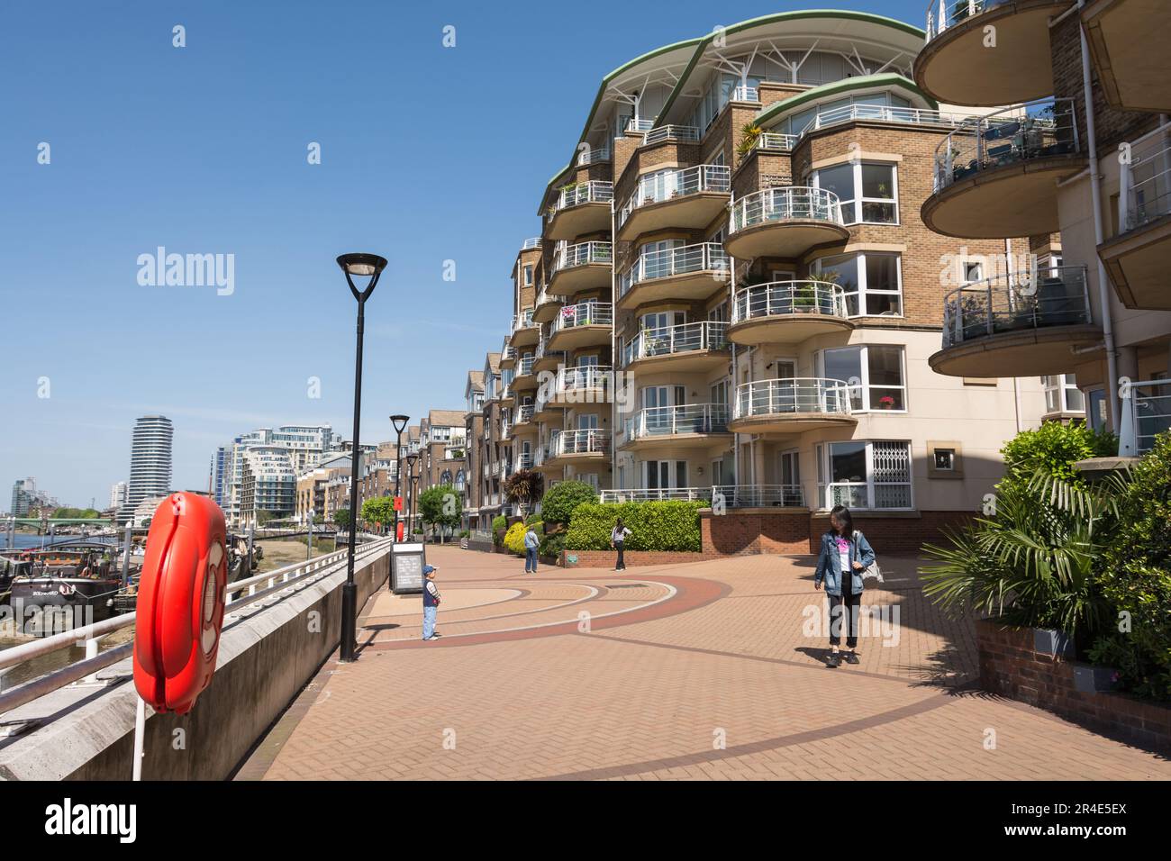 Une mère et un enfant à côté des bateaux à moteur et des appartements sur Clove Hitch Quay, Clapham Junction, Londres, SW11, Angleterre, ROYAUME-UNI Banque D'Images