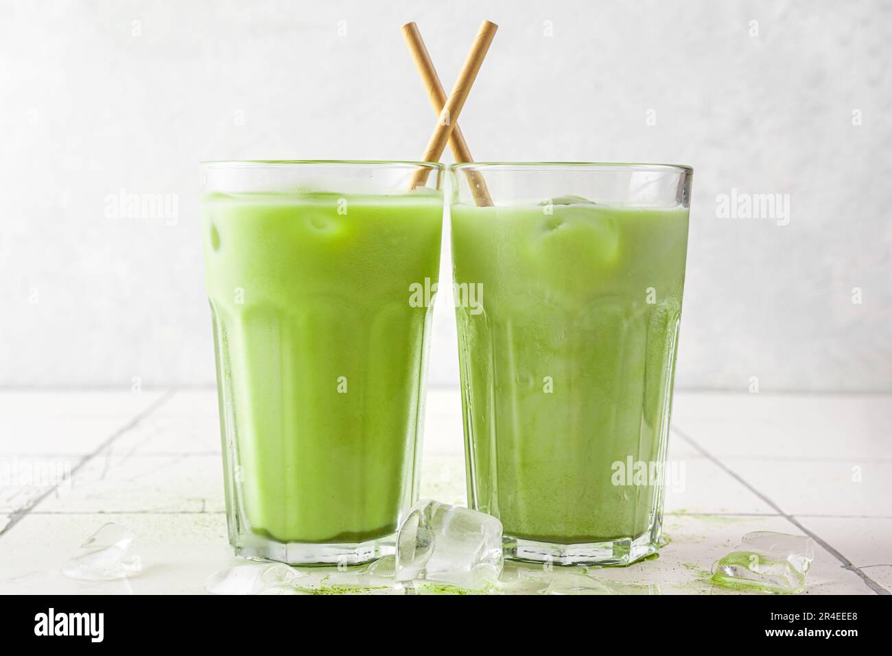 Latte matcha vert glacé dans des verres avec une paille sur fond blanc. Boisson d'été froide Banque D'Images