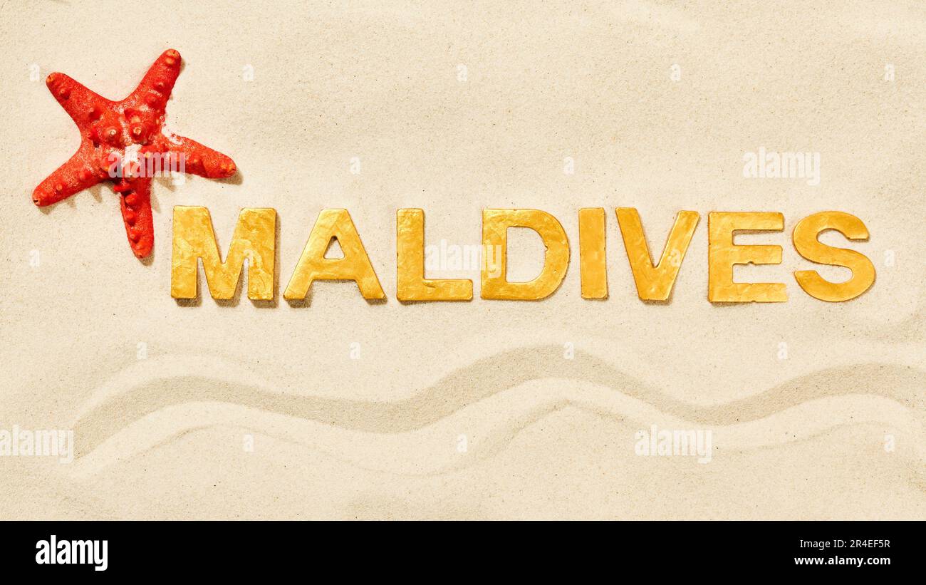 Maldives - Mot par lettres d'or dans le sable blanc Banque D'Images