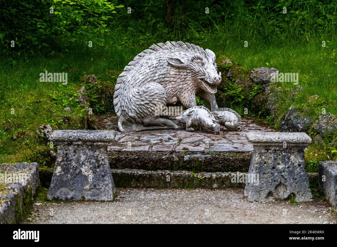La niche du sanglier des eaux usées dans le parc du château de Hellbrunn à Salzbourg, en Autriche, montre une mère sanglier avec deux porcelets sur un socle de maçonnerie entre deux bancs en pierre. Banque D'Images