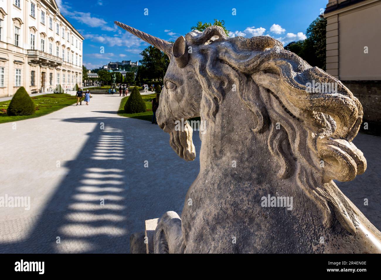 La tête d'un des licornes de pierre apparaît dans l'image dans les jardins du palais de Mirabell à Salzbourg, en Autriche. Le palais et la forteresse de Hohensalzburg sont visibles en arrière-plan. Les statues rappellent la scène « Do-Re-Mi » du film « La Mélodie du bonheur » de 1965, dont une partie a été tournée dans les jardins de Mirabell. Banque D'Images