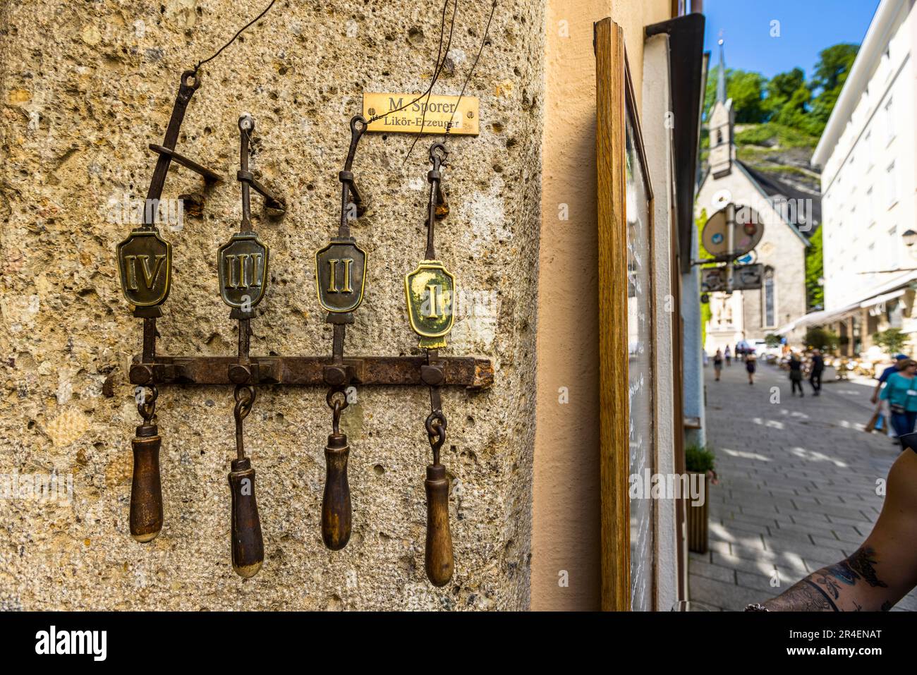 Une plaque en laiton portant l'inscription « M. Sporer Likör-Erzeuger » et, en dessous, quatre cordons de sonnette numérotés et anciens sont accrochés à la façade de la manufacture de liqueurs et de punch Sporer à Salzbourg, en Autriche. La famille dirige l'entreprise depuis 1903, maintenant dans sa quatrième génération. Banque D'Images